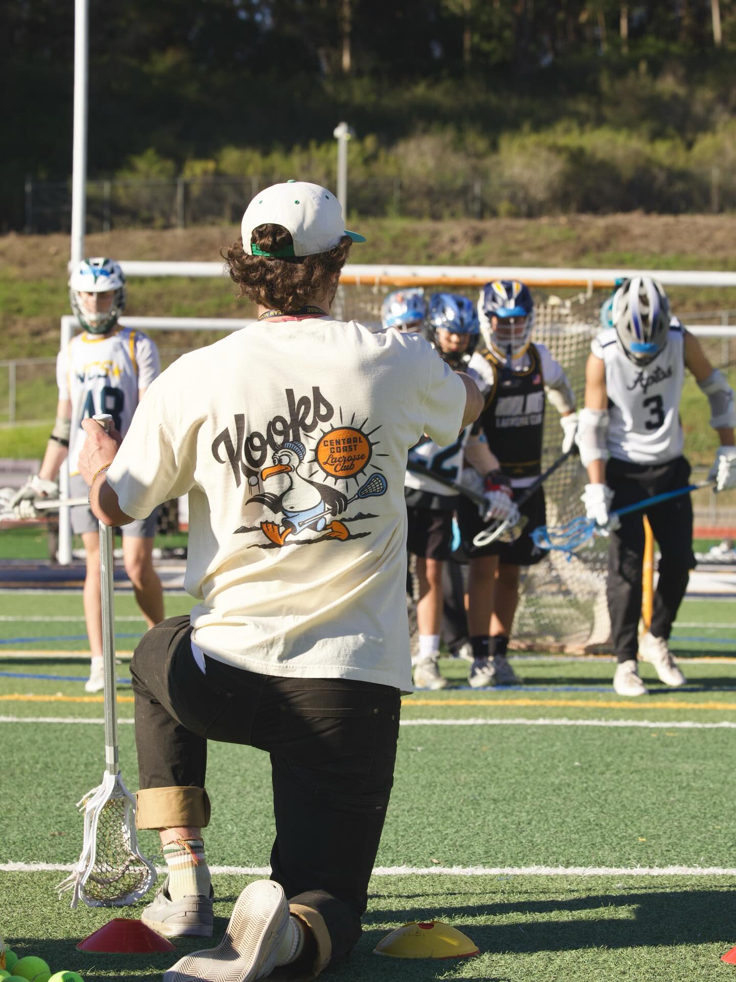Aidan Niklaus coaching youth players at a Kooks Lacrosse Club clinic at Aptos High School