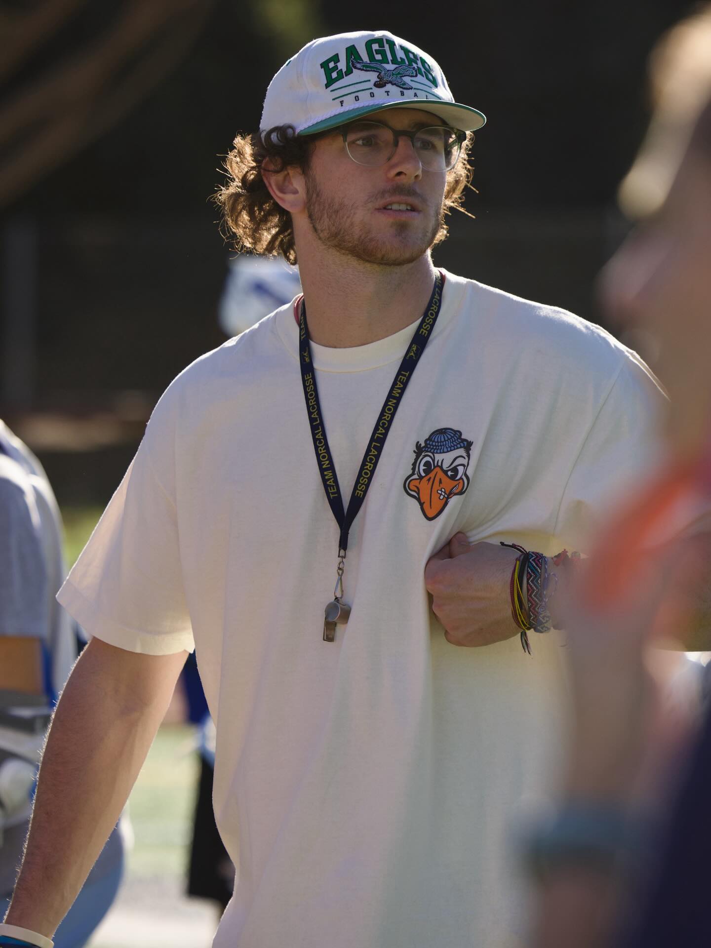 Close-up portrait of Aidan Niklaus in Eagles hat and Kooks shirt with whistle and Team NorCal lanyard