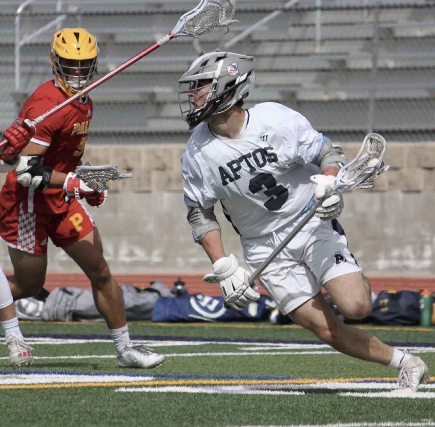 Kale Lampman driving past a Palma defender in Aptos Mariners white